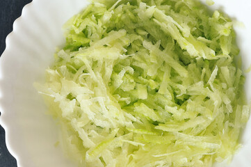 green radish salad in a white plate - top view