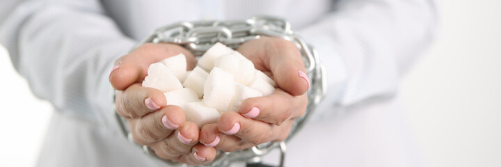 Female tied hands with hold white lump sugar chain closeup