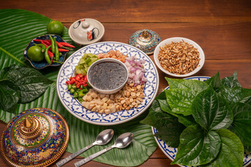 Miang Kham Or wild betel leaves Wrap Ingredients dried shrimps, peanuts, lime, chilli, roasted peanuts with sweet dipping sauce,  Asian appetizer food.