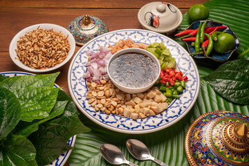 Miang Kham Or wild betel leaves Wrap Ingredients dried shrimps, peanuts, lime, chilli, roasted peanuts with sweet dipping sauce,  Asian appetizer food.
