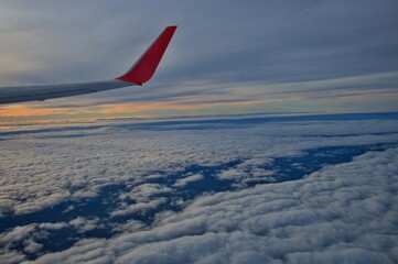 View of the wing of an airplane flying above the clouds