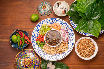 Miang Kham Or wild betel leaves Wrap Ingredients dried shrimps, peanuts, lime, chilli, roasted peanuts with sweet dipping sauce,  Asian appetizer food.
