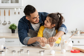 Obraz na płótnie Canvas Father Daughter Leisure. Happy Arab Dad Baking With Female Child In Kitchen