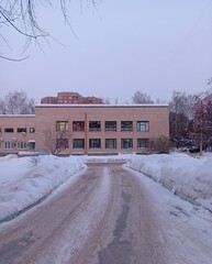 frozen path to a beige building with windows
