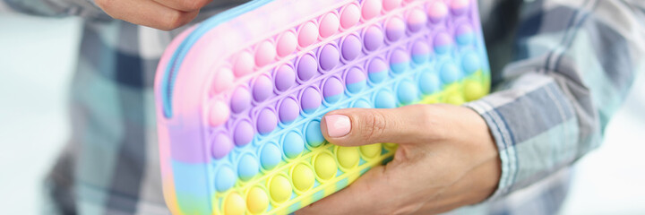 Woman is unbuttoning bright pops it pencil case