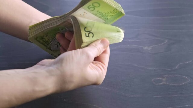 4k. Close-up view of counting stack of belarusian 50 ruble paper money. Hands hold and count a lot of cash. Saving. National currency of Belarus. Credit liabilities. Profit. Big debt. Taxes payment.