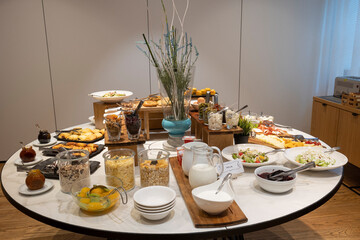 Breakfast served on a round buffet table in a hotel restaurant