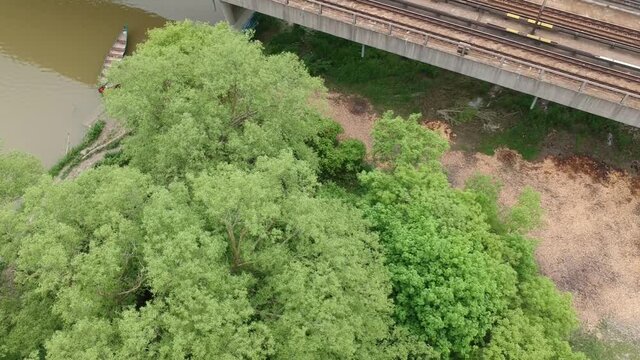 Drone Flyby and Rise beside Subway train track river and canoes