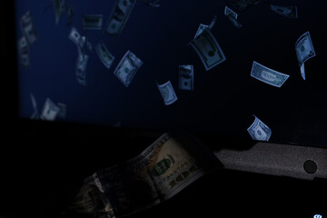 American hundred dollars on the keyboard of an office laptop