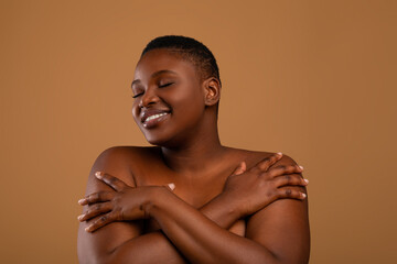Portrait of beautiful plus size African american woman embracing herself © Prostock-studio