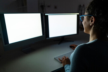 Freelancer working on two monitors at home office