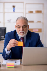 Fototapeta premium Old male employee working in the office
