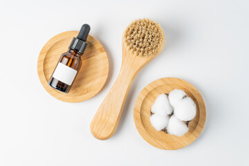 Naklejka na ściany i meble Skin care products - body or face brush with natural bristle and bottle with serum on white background,. spa and relaxation products. Unbranded mockup