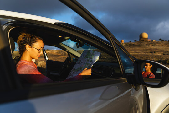 Young woman holding map in car