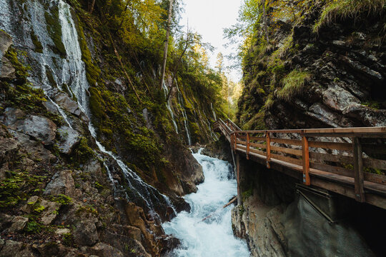 Elevated walkway stretching over river flowing through narrow ravine