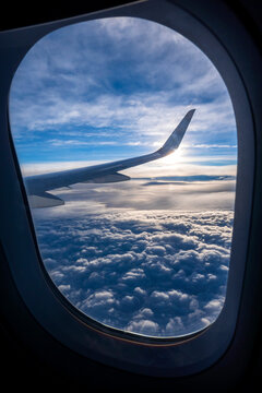 Thick clouds seen through window of airplane flying above