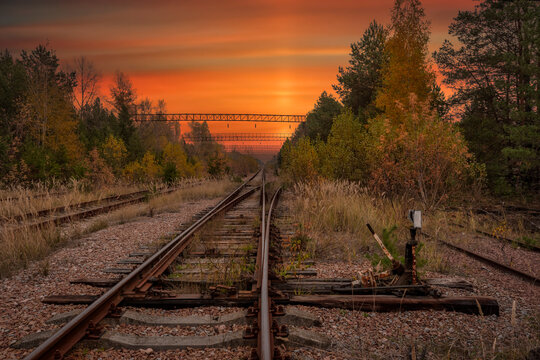 Ukraine, Kyiv Oblast, Chernobyl, Abandoned railroad tracks at fiery dusk