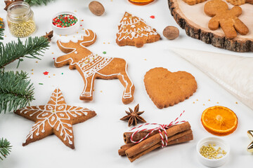 Christmas preparations. Hands decorate handmade Christmas gingerbread with glaze, icing sugar. Female hands paint Christmas gingerbread cookies.
