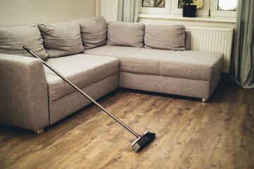 broom leaning against the couch
