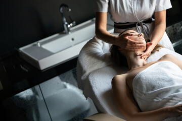 Beautiful young woman getting spa massage treatment at beauty spa salon
