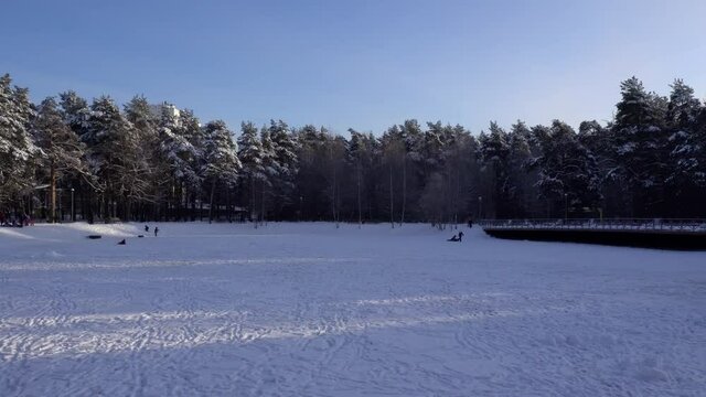 Winter recreational activities on the frozen snowy pond of city park. Moscow, Russia