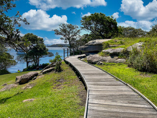 Coastal wooden hiking path under blue cloudy sky