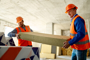 Two builders unload construction material at storehouse