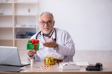 Old male doctor celebrating Christmas at the hospital