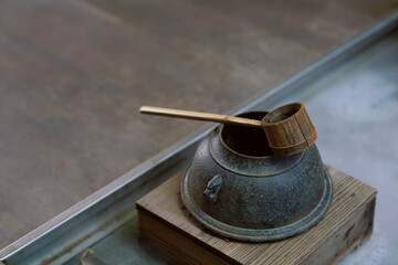 Gardening Japanese style inspiration from tea ceremony, bamboo dipper with old kettle chagama with smoke floating                      