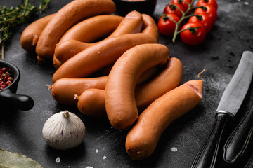 Raw roll sausages, on black dark stone table background