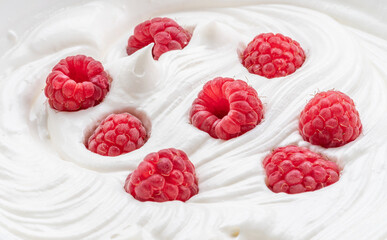 Fresh raspberries in the yoghurt or cream. Top view.