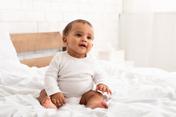 Sweet African American Infant Baby Sitting In Bed Indoor