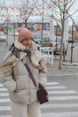 Beautiful baby boomer woman of middle age in glasses and stylish casual clothes on the street.