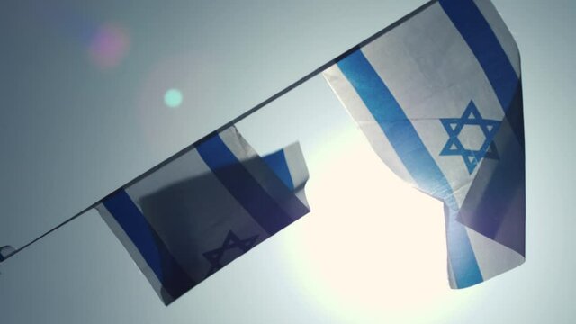 Flag of israel fluttering in the wind against the backdrop of the sun