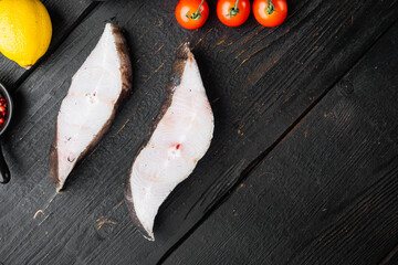 Raw halibut saltwater fish steak, with ingredients and rosemary herbs, on black wooden table background, top view flat lay, with copy space for text