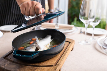 dorado fish in pan prepared for table in restaurant. pike perch defocused
