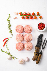 Semi finished products, meatballs, meat patties in plastic pack, on white stone table background, top view flat lay
