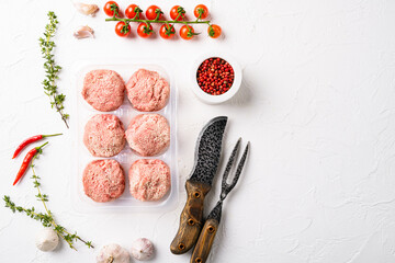 The patties of minced meat on a tray, on white stone table background, top view flat lay, with copy space for text