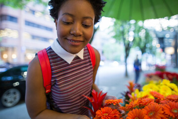 Businesswoman choosing flowers at sidewalk florist in city