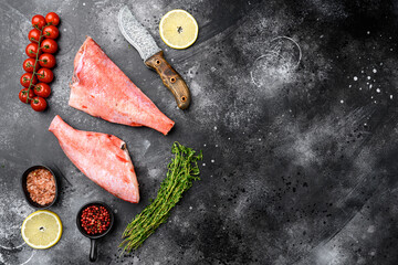 Whole raw red snapper fish, on black dark stone table background, top view flat lay, with copy space for text - obrazy, fototapety, plakaty