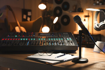 Microphone and professional mixing console on table in radio studio