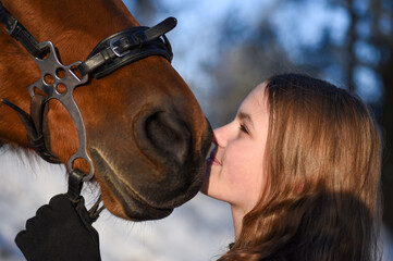 Obraz premium Portrait of a young girl with a horse in winter