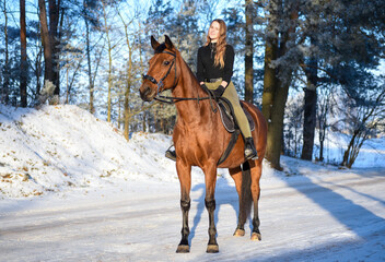 Naklejka na ściany i meble Young girl with horse on winter forest road