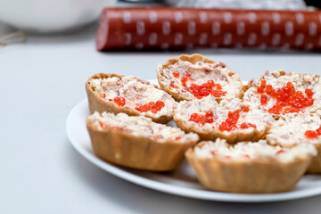 On the plates there are baskets with p?t? and red caviar.