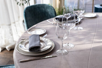 table serving with tablewear glasses and plates in restaurant. selected focus