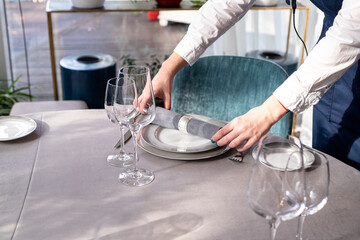 Fototapeta na wymiar table serving with tablewear glasses and plates in restaurant. selected focus
