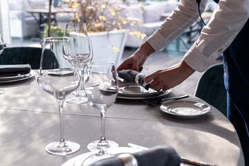 table serving with tablewear glasses and plates in restaurant. selected focus