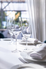table serving with tablewear glasses and plates in restaurant. selected focus