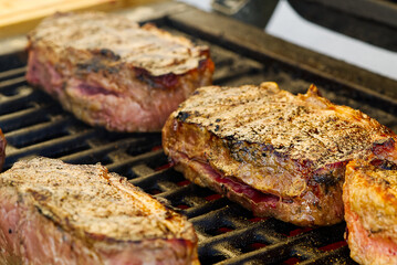 grilling steaks on gas grill and shot with selective focus.