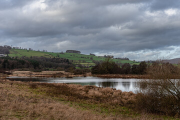 Grey clouds over pond in UK countryside